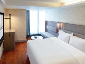 a hotel room with a large bed and a television at Mercure Chongqing Downtown in Chongqing +113 photos