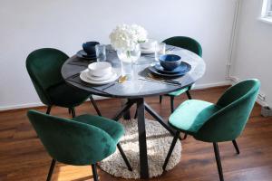 a dining room table with green chairs and a glass table at Onyx Place Spacious 3BR Home l Fast London Commute l Parking in North Ockendon