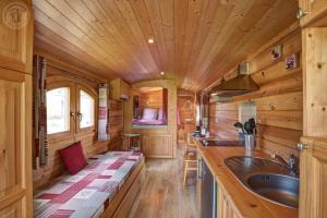 a kitchen with wooden walls and a wooden ceiling at La roulotte à la ferme in Palogneux