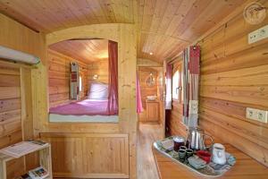 a room with a bed in a wooden cabin at La roulotte à la ferme in Palogneux