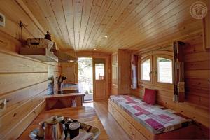 a log cabin with a bench in the middle of a room at La roulotte à la ferme in Palogneux