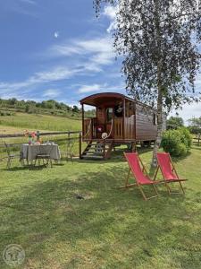 a group of chairs and a table and a rv at La roulotte à la ferme in Palogneux +9 photos