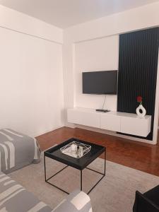 a living room with a tv and a coffee table at AP Museu Maputo in Maputo