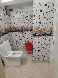 a bathroom with a toilet and a wall with polka dots at New Vybent Hotel Kainchi Dham in Bhowāli
