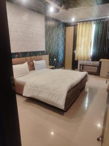 a bedroom with a large bed in a room at New Vybent Hotel Kainchi Dham in Bhowāli