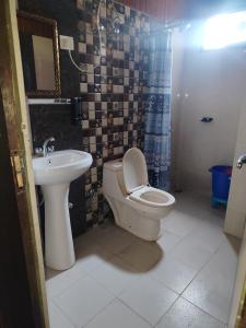 a bathroom with a toilet and a sink at New Vybent Hotel Kainchi Dham in Bhowāli +10 photos