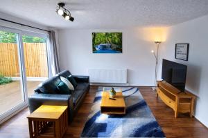 a living room with a couch and a tv at Onyx Place Spacious 3BR Home l Fast London Commute l Parking in North Ockendon