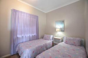 a bedroom with two beds and a window at Rabe's Rest in Yzerfontein