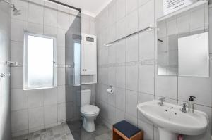 a white bathroom with a toilet and a sink at Rabe's Rest in Yzerfontein