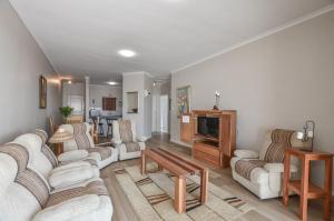 a living room with two couches and a tv at Rabe's Rest in Yzerfontein