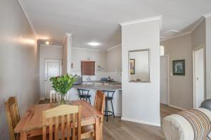 a dining room and kitchen with a table and chairs at Rabe's Rest in Yzerfontein +11 photos