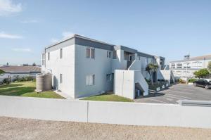 a blue and white building with a parking lot at Rabe's Rest in Yzerfontein