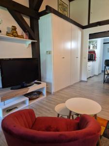a living room with a red chair and a table at Ferienwohnung Atelier in Siegsdorf