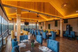 a restaurant with blue chairs and tables in a room at River View Resort in Haridwār