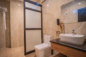 a bathroom with a toilet and a sink and a shower at River View Resort in Haridwār +55 photos