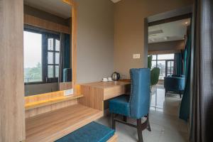 a room with a desk and a chair and a mirror at River View Resort in Haridwār