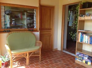 a green chair in a room with a book shelf at Au rythme d Arduinna in Touligny