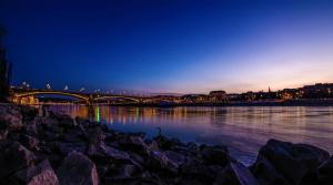 a bridge over a body of water at night at Roombach Hotel Budapest Center in Budapest