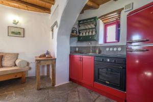 a kitchen with red cabinets and a stove at Marketos Traditional Windmill in Tripiti