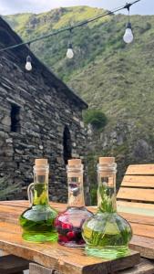 two glass bottles sitting on top of a wooden table at Firefly in Shatili +7 photos