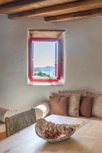 a table with a bowl of fruit on it in front of a window at Marketos Traditional Windmill in Tripiti