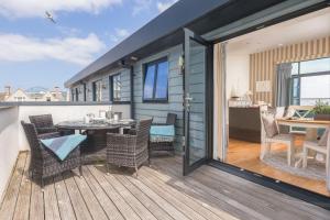 a tiny house with a deck with a table and chairs at Porthminster Mews 2 in St Ives