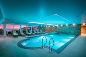 a pool in a building with chairs and a table at Porthminster Mews 2 in St Ives