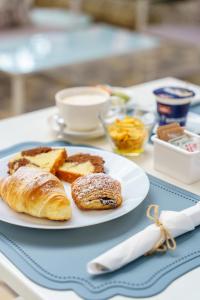 a plate of bread and pastries on a table at Pietra Bianca Rooms in Pachino +48 photos
