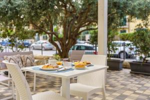 a table with plates of food on a patio at Pietra Bianca Rooms in Pachino