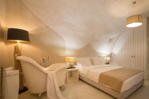 1 dormitorio con cama, escritorio y silla en The Dream Santorini, en Oia
