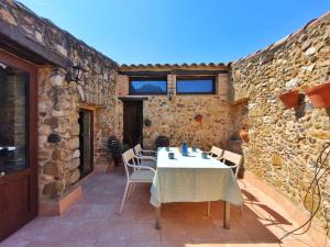 a patio with a table and chairs in a stone building at Casa historica en Corçà, Baix Empordà in Corçà