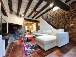a living room with a white couch and a fireplace at Casa historica en Corçà, Baix Empordà in Corçà
