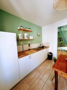 a kitchen with white cabinets and a table at Le Temps d une Pause in Calais