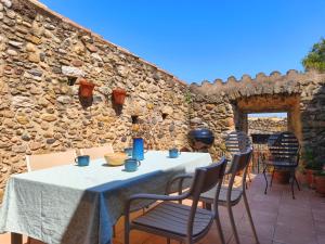 a table and chairs on a patio with a stone wall at Casa historica en Corçà, Baix Empordà in Corçà
