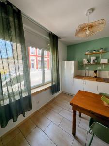 a kitchen with a table and a large window at Le Temps d une Pause in Calais