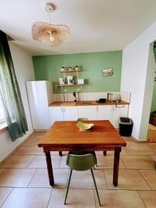 a kitchen with a wooden table and a green wall at Le Temps d une Pause in Calais +26 photos