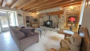 a living room with a couch and a stone wall at La petite ecosse in Châteauneuf-la-Forêt