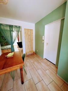 a dining room with a wooden table and a door at Le Temps d une Pause in Calais