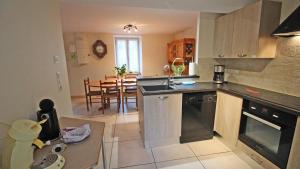 a kitchen and dining room with a table in it at La petite ecosse in Châteauneuf-la-Forêt