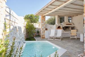 a patio with a swimming pool and a table and chairs at Villa Joy in Aliki