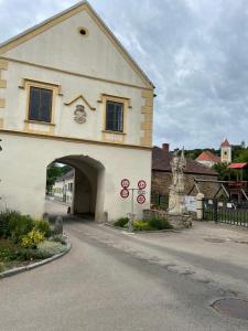 a large white building with an archway next to a street at Ferienwohung in Maissau in Maissau