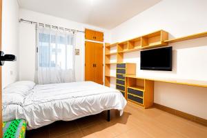 a bedroom with a bed and a flat screen tv at Escondite Brisa Marina in Calpe