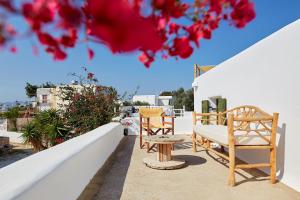 two chairs and a table on a balcony with flowers at Villa Joy in Aliki
