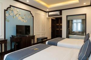 a hotel room with two beds and a flat screen tv at Kana Boutique Hotel Ninh Bình in Ða Gia +39 photos
