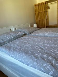a bed with a blue blanket on top of it at Ferienwohung in Maissau in Maissau