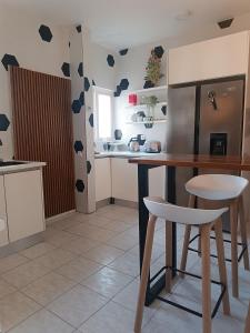 a kitchen with a counter and a table and chairs at AP Museu Maputo in Maputo