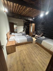 a bedroom with two beds and a stone wall at Firefly in Shatili