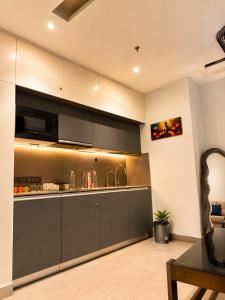 a kitchen with gray cabinets and a microwave at Skyvera Stay at Supernova Spira in New Delhi +4 photos