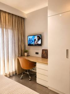 a bedroom with a desk with a television on a wall at Skyvera Stay at Supernova Spira in New Delhi