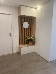 a hallway with a mirror and a plant on a counter at Refúgio da Barra in Gafanha da Nazaré